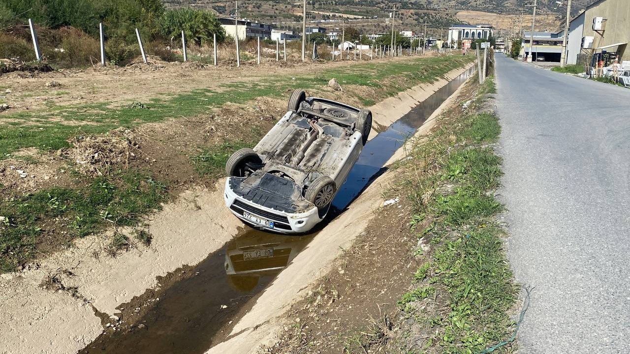 Kanala uçup ters dönen araçtan burunları bile kanamadan çıktılar

