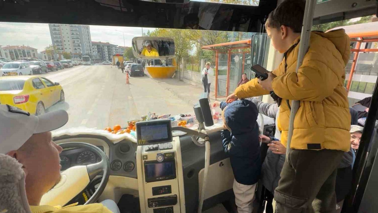 Şoför minibüse binen yolcularına meyve ve şekerleme ikram ediyor

