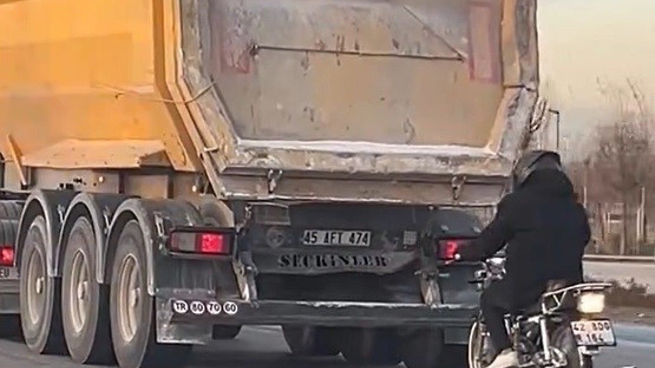 Seyir halindeki tırın peşinde motosikletli tehlikeli yolculuk
