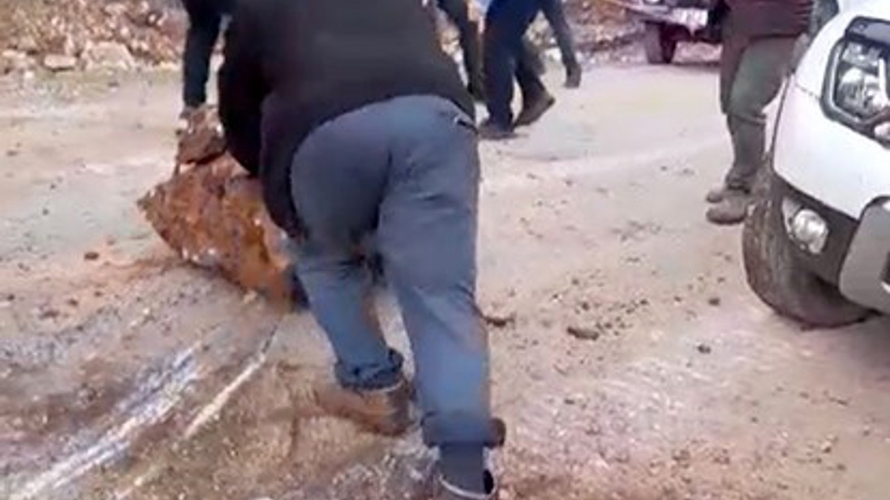 Yola düşen kayaları iple araca bağlayıp çektiler
