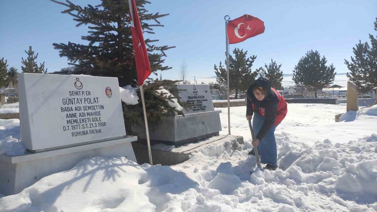 Karla kaplanan şehitlikte temizlik yaptılar
