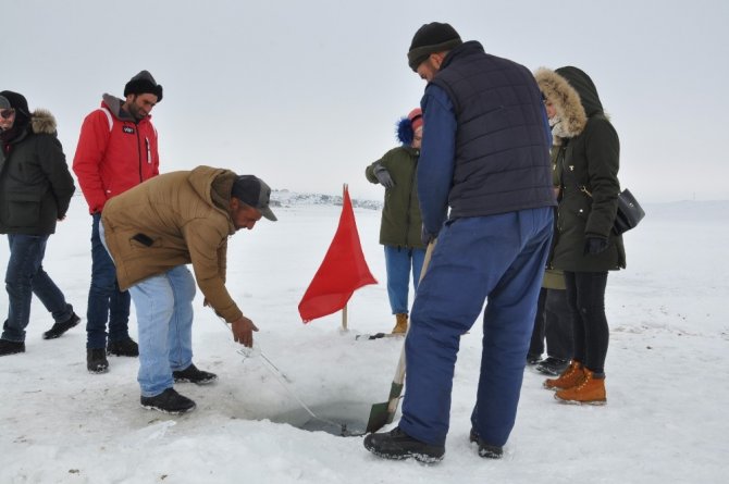 Köylü gençler misafirlere Eskimo usulü balık tutturuyor